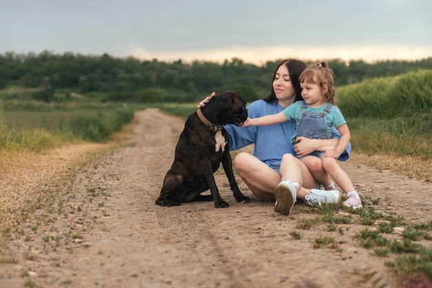 due sorelle con un cane per una passeggiata fuori città in estate