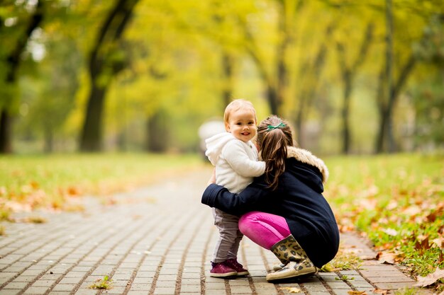 Due sorelle della bambina nel parco di autunno