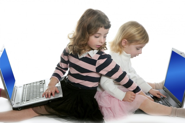 Due sorelle di bambine con computer portatili