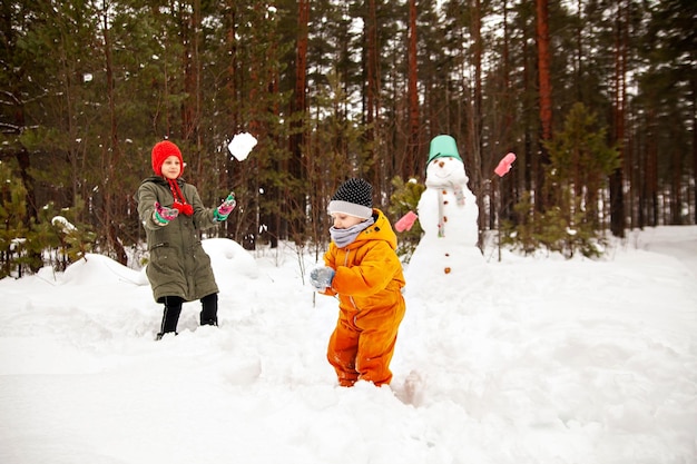 Due sorelle fanno un pupazzo di neve in inverno