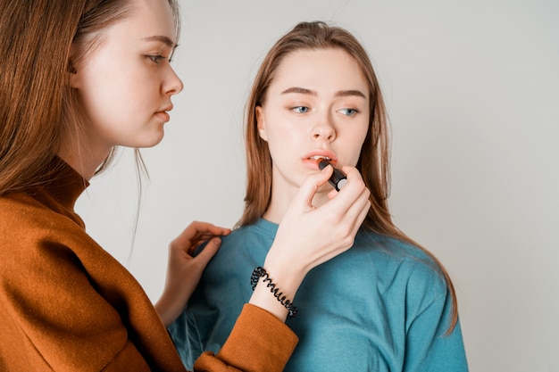 Due sorelle gemella bellissime ragazze con le labbra che dipingono casual