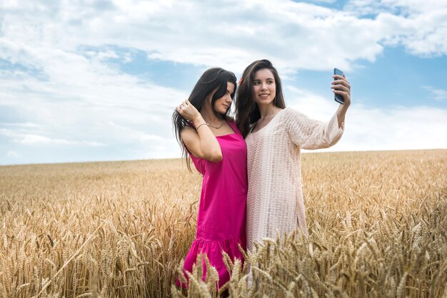 Due sorelle graziose godono della libertà nel campo di grano