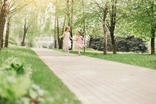 Due sorelline corrono lungo il sentiero del parco cittadino