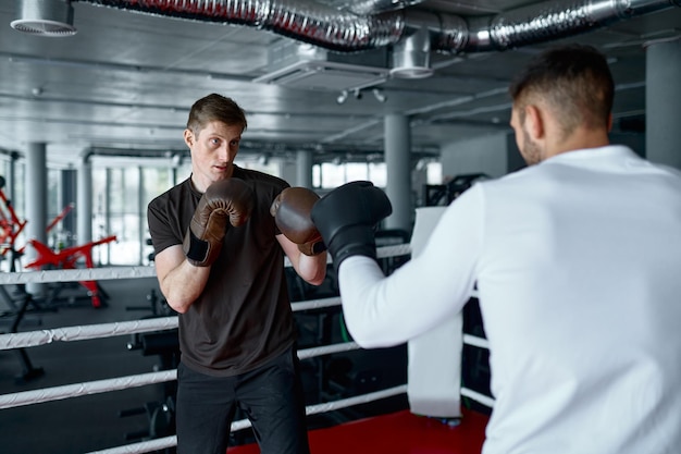 Due sparring partner nei guantoni da boxe si esercitano a calci