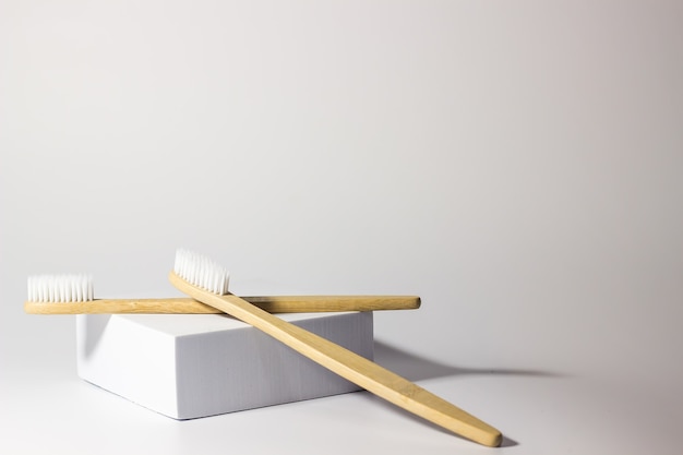 due spazzolini da denti di bambù su una piattaforma o stare su uno sfondo bianco