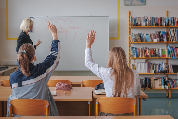 Due studentesse durante una lezione in classe ascoltano e comunicano con la formazione di un insegnante