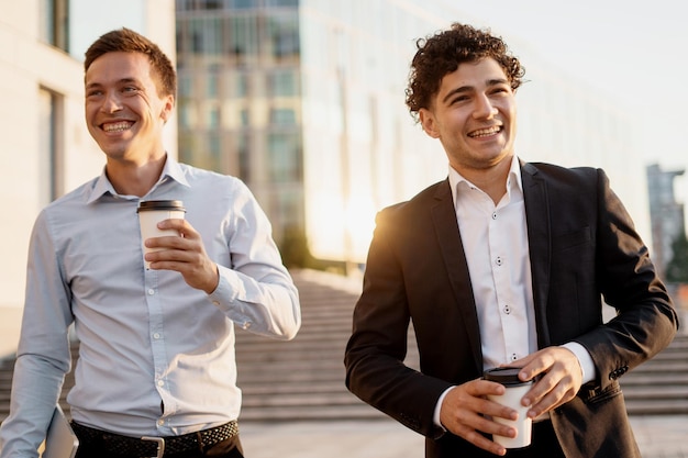 Due studenti avvocati bevono caffè uomini in giacca e cravatta vanno a lavorare in un nuovo ufficio