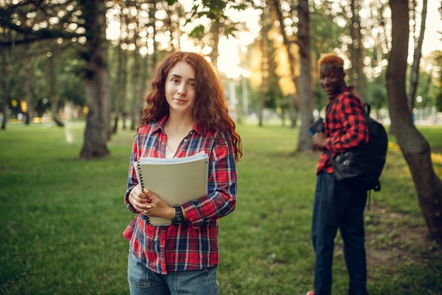 Due studenti che camminano sul prato nel parco estivo