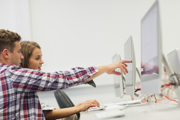 Due studenti che lavorano al computer che punta a questo