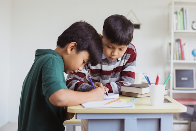 Due studenti elementari asiatici che studiano insieme in classe