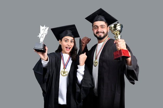 Due studenti il giorno della laurea con il trofeo sulle mani modello pakistano indiano