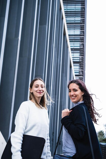 Due studenti studenti che parlano e sorridono al di fuori di un centro di studio Studenti adulti di studio a distanza