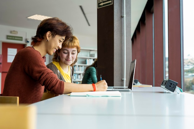 Due studenti universitari che studiano insieme in una biblioteca