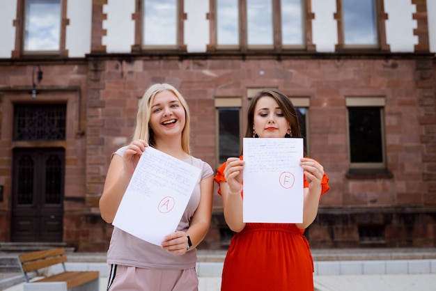 Due studenti vicino all'università con i risultati dei test