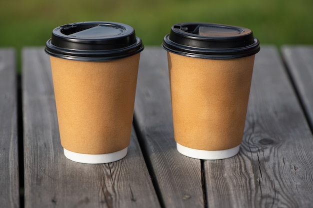 Due tazza di caffè di carta gialla su una superficie di legno per caffè e andare in servizio.