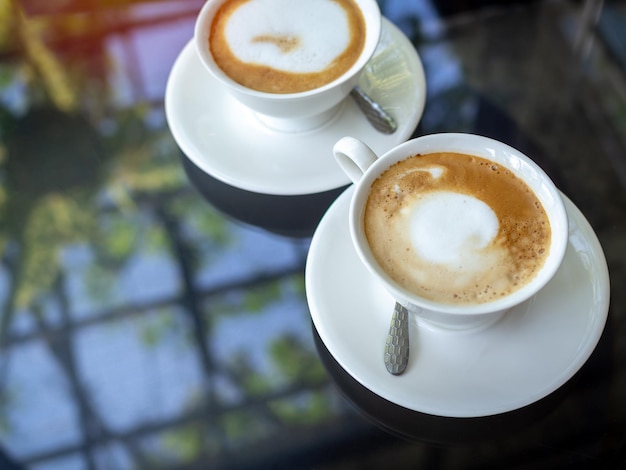 Due tazze da caffè in ceramica bianca sul tavolo di vetro