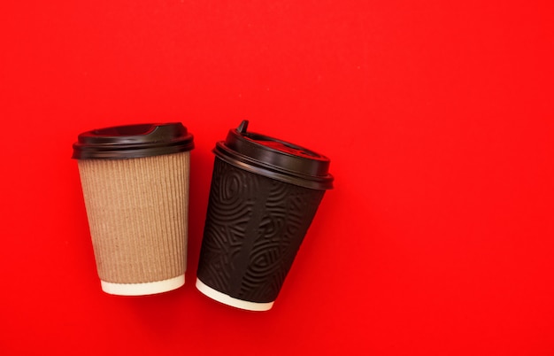 Due tazze di caffè di carta sulla tavola rossa, vista superiore
