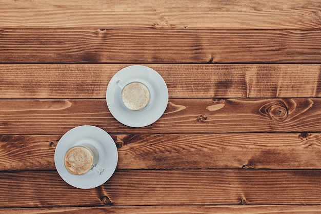 Due tazze di caffè sullo sfondo marrone in legno terrazza. Foto di alta qualità