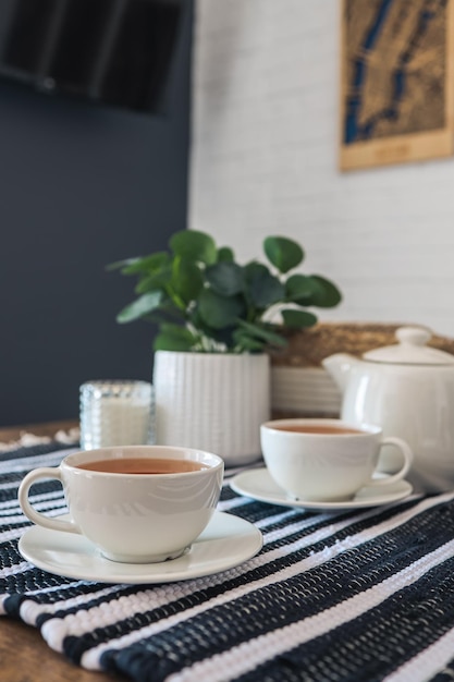 Due tazze di tè bevendo il tè nella cucina scandinava Bella fotografia di interni di casa accogliente