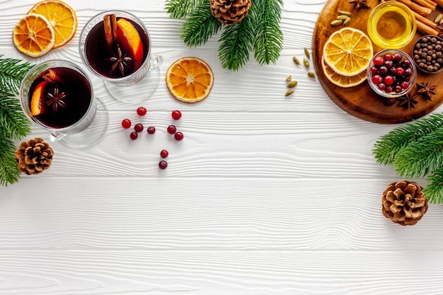 Due tazze di vin brulè, spezie e agrumi secchi riscaldano la bevanda natalizia