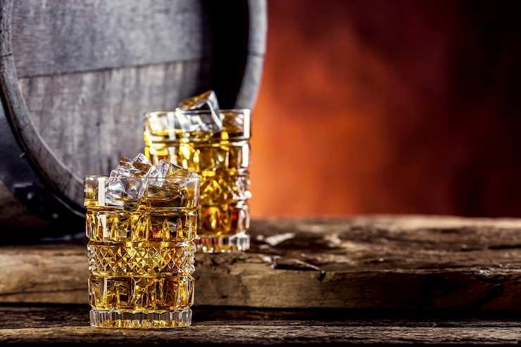 Foto due tazze piene di bevanda whisky brandy o cognac con cubetti di ghiaccio in stile retrò