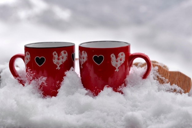 Due tazze rosse con cuore a forma di concetto di San Valentino neve