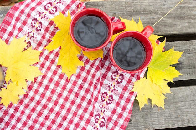 Due tazze rosse su fogli gialli, autunno