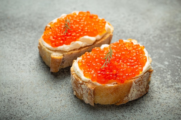 Due toast al caviale, baguette con burro e salmone rosso.