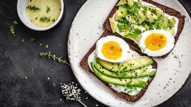 Due toast con uovo in camicia di avocado e dieta microgreen o cibo vegetariano Vista dall'alto