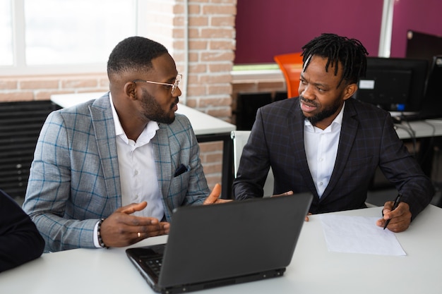 due uomini africani in ufficio con il computer portatile