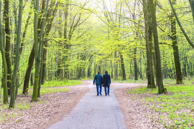 Due uomini che camminano nel parco verde