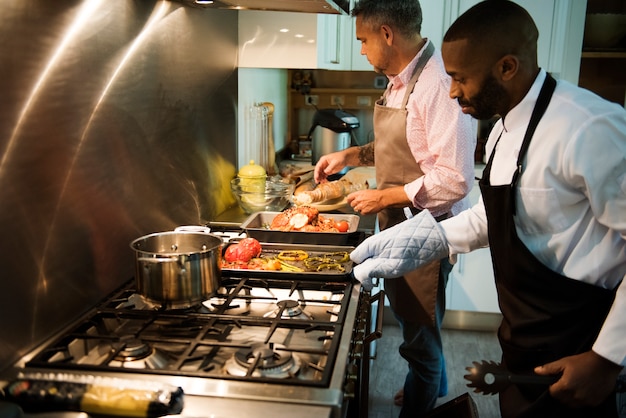 Due uomini che cucinano in una cucina