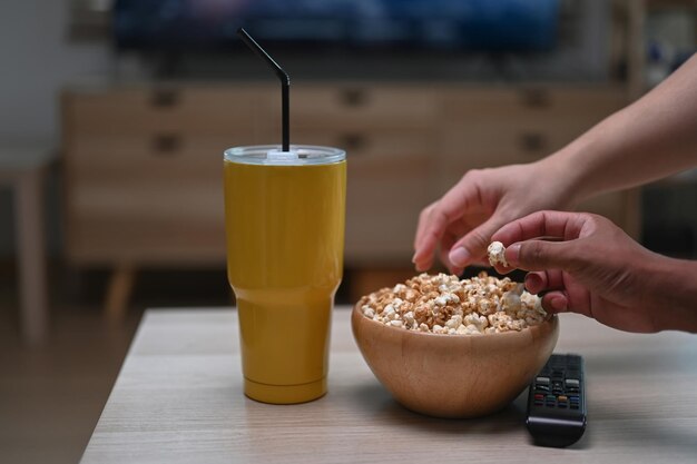 Due uomini che guardano la TV e mangiano popcorn in soggiorno