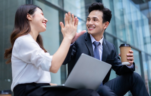 Due uomini d'affari asiatici stanno discutendo il lavoro durante la ricreazione