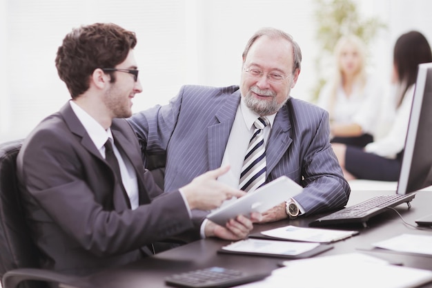 Due uomini d'affari che discutono di problemi di lavoro seduti alla loro scrivania