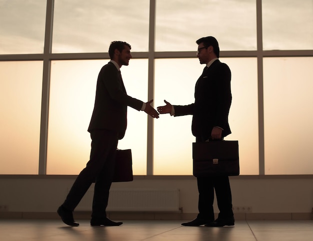 Due uomini d'affari che tendono le mani per una foto di handshake con lo spazio della copia