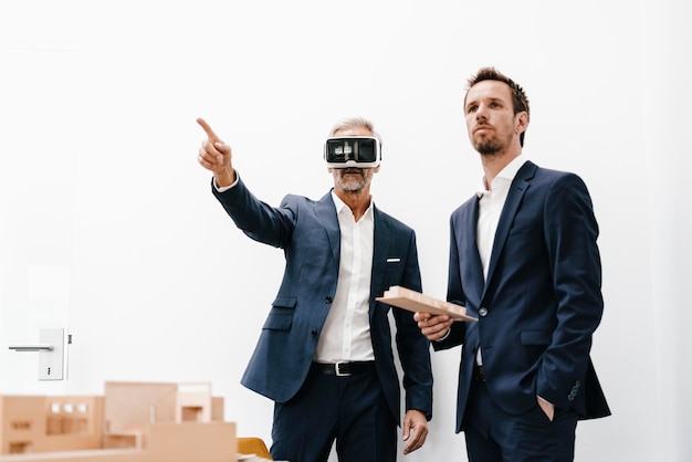 Due uomini d'affari con occhiali VR e modello architettonico