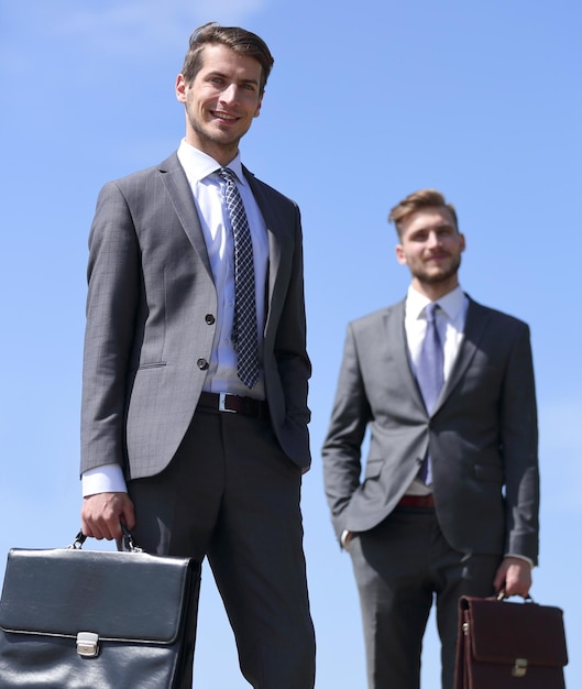Due uomini d'affari con valigette in pelle con spazio per la copia