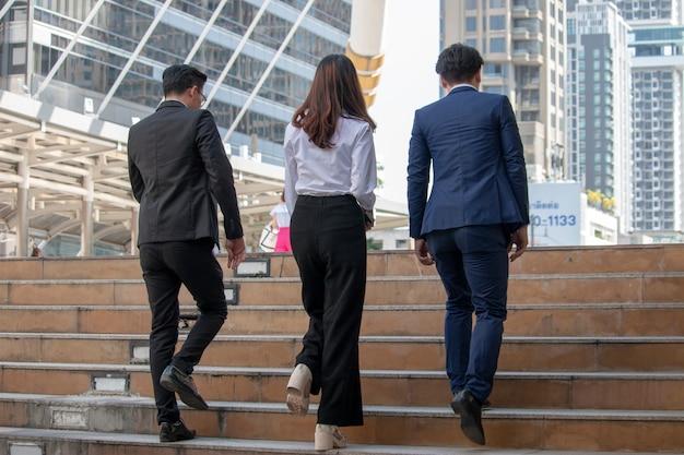 Due uomini d&#39;affari e una donna d&#39;affari passeggiano sui gradini della città