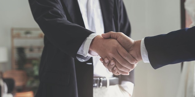 Due uomini d'affari fiduciosi che stringono la mano durante una riunione nell'ufficio successo che si occupa di saluto e concetto di partner