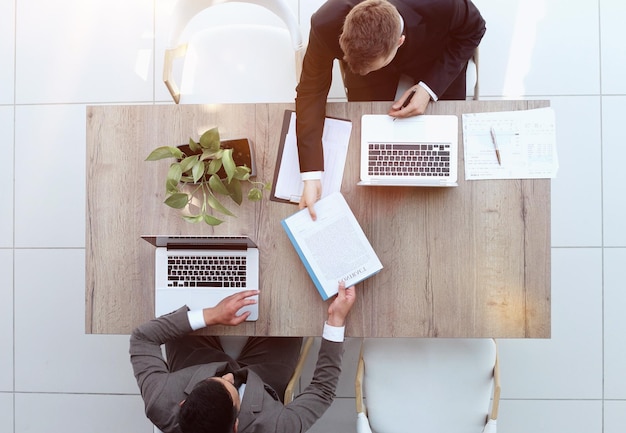 Due uomini d'affari sorridenti di successo stanno lavorando su una vista del laptop dall'alto