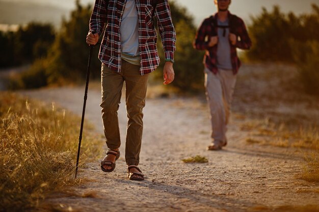 Due uomini escursionisti si godono una passeggiata nella natura al tramonto in estate