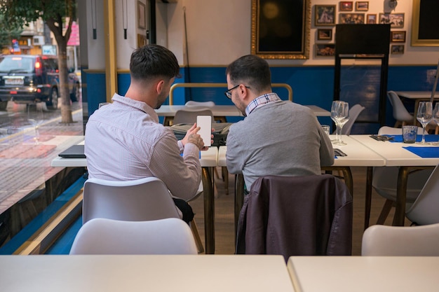 Due uomini stanno cercando un telefono cellulare da un ristorante