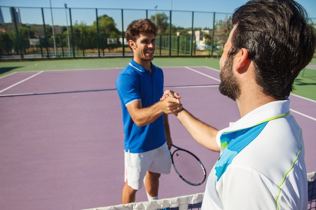 Due uomini, tennisti professionisti si stringono la mano prima e dopo la partita di tennis