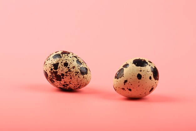 Due uova di quaglia su sfondo rosa