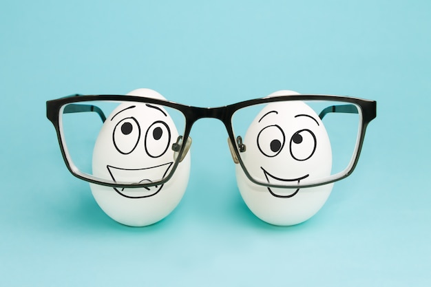Due uova divertenti guardano attraverso le lenti degli occhiali. Correzione della visione
