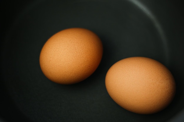 Due uova marroni in una pentola d'acqua sul fornello