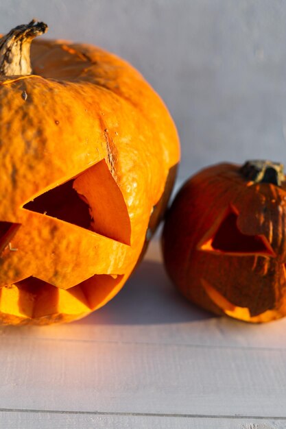 Due zucche arancioni su un tavolo di legno bianco al tramonto Buon Halloween