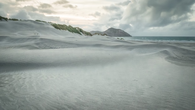 Dune di sabbia bianca sulla spiaggia riprese durante il tramonto sulla spiaggia di Wharariki in Nuova Zelanda