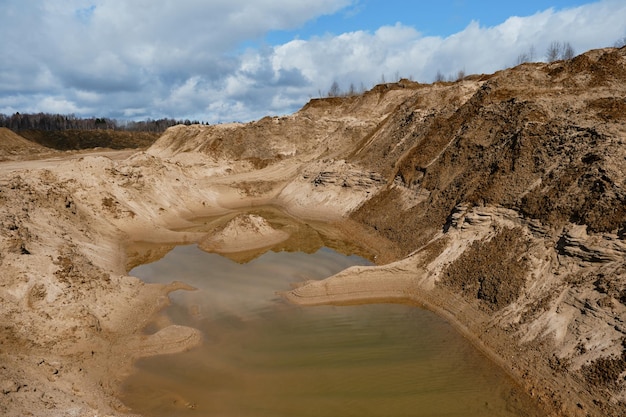 Dune di sabbia su tutti i lati e uno stagno artificiale al centro Una piccola isola di sabbia nell'acqua